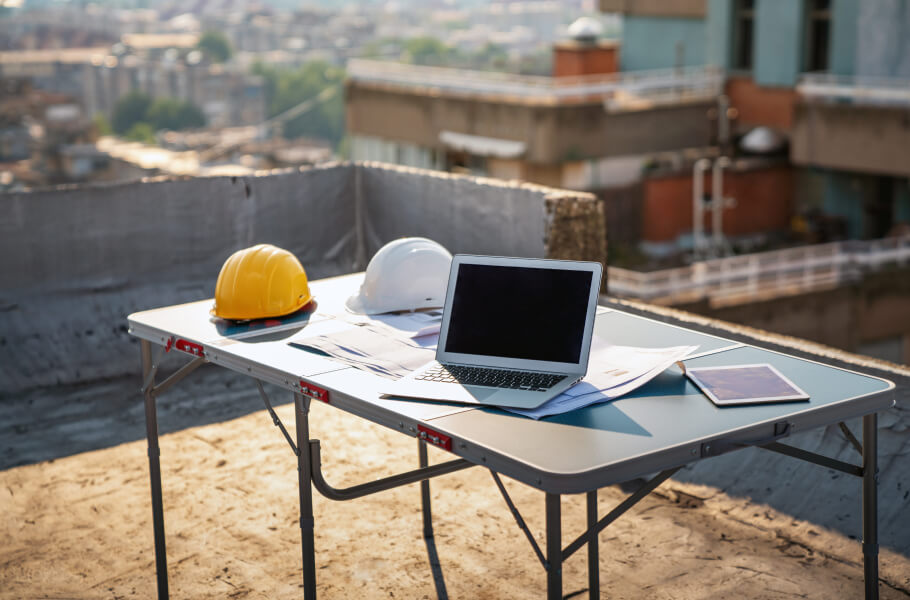 A laptop and construction helmet above the table