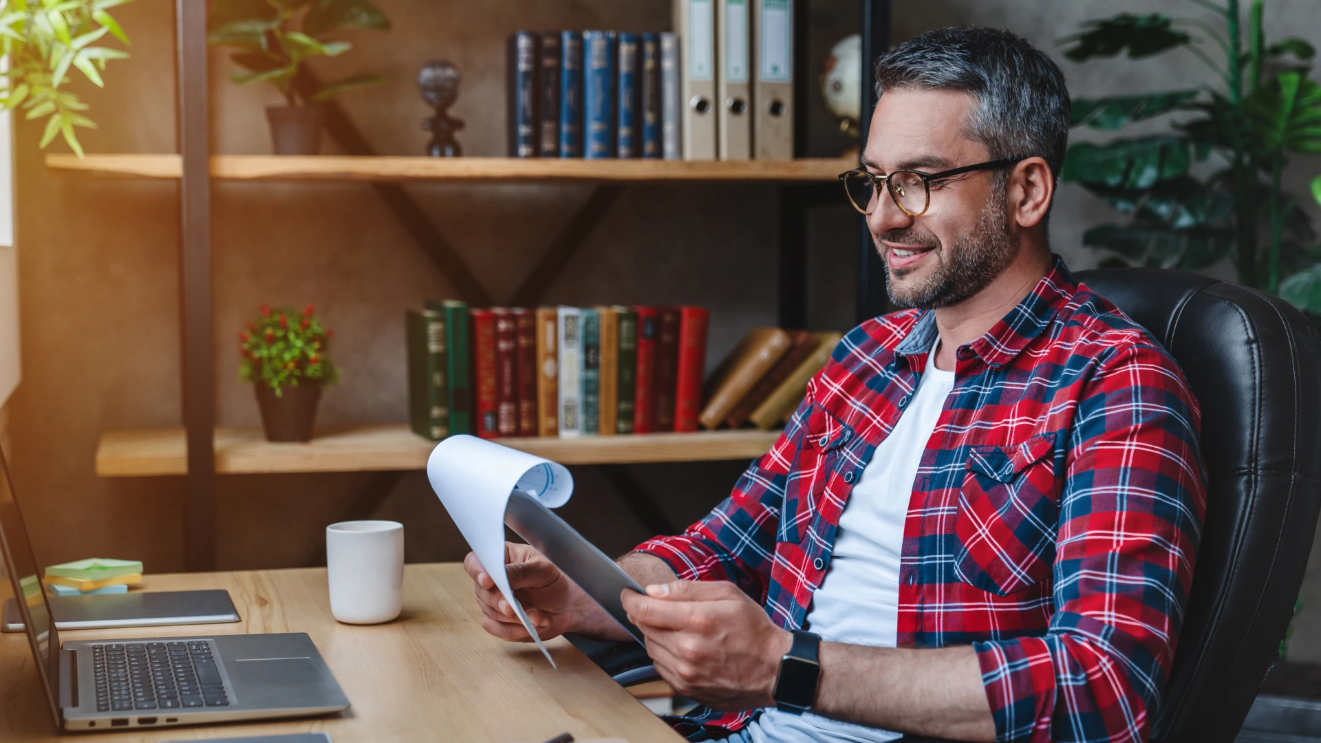 A man analyzes reading documents statistics and working on laptop