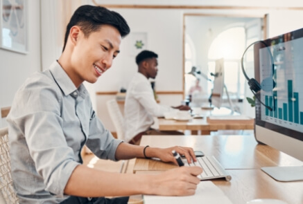 A man smilling while writing in a paper