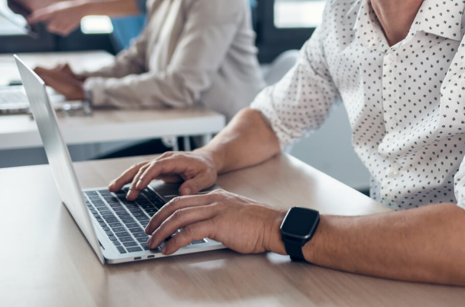 A man wearing white sleeve using laptop