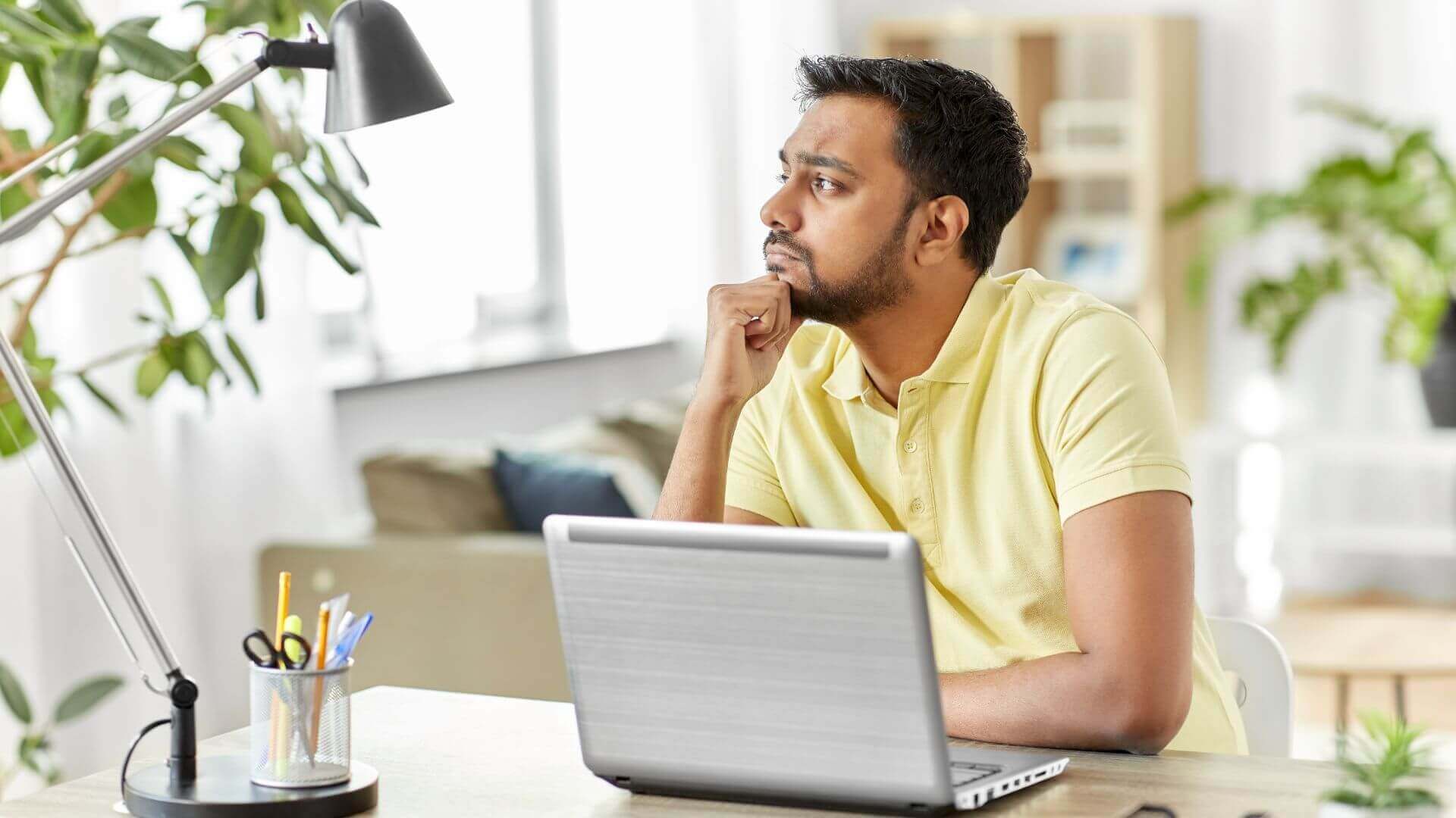 A men thinking in front of her in laptop