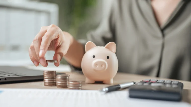 A woman puts coins in a piggy bank