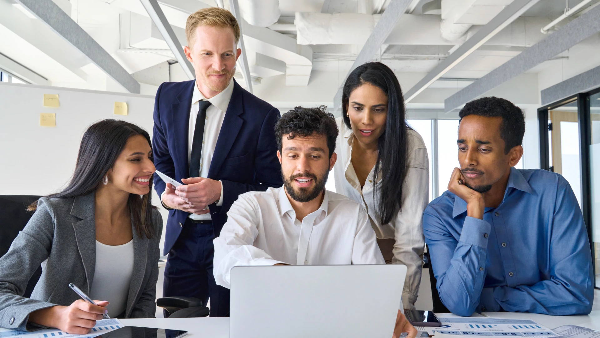 Busy diverse professional business people executives looking at laptop in office