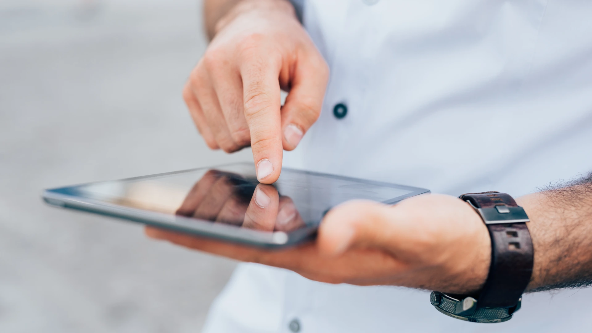 Close up businessman using tablet handhold - business person analysing stategies