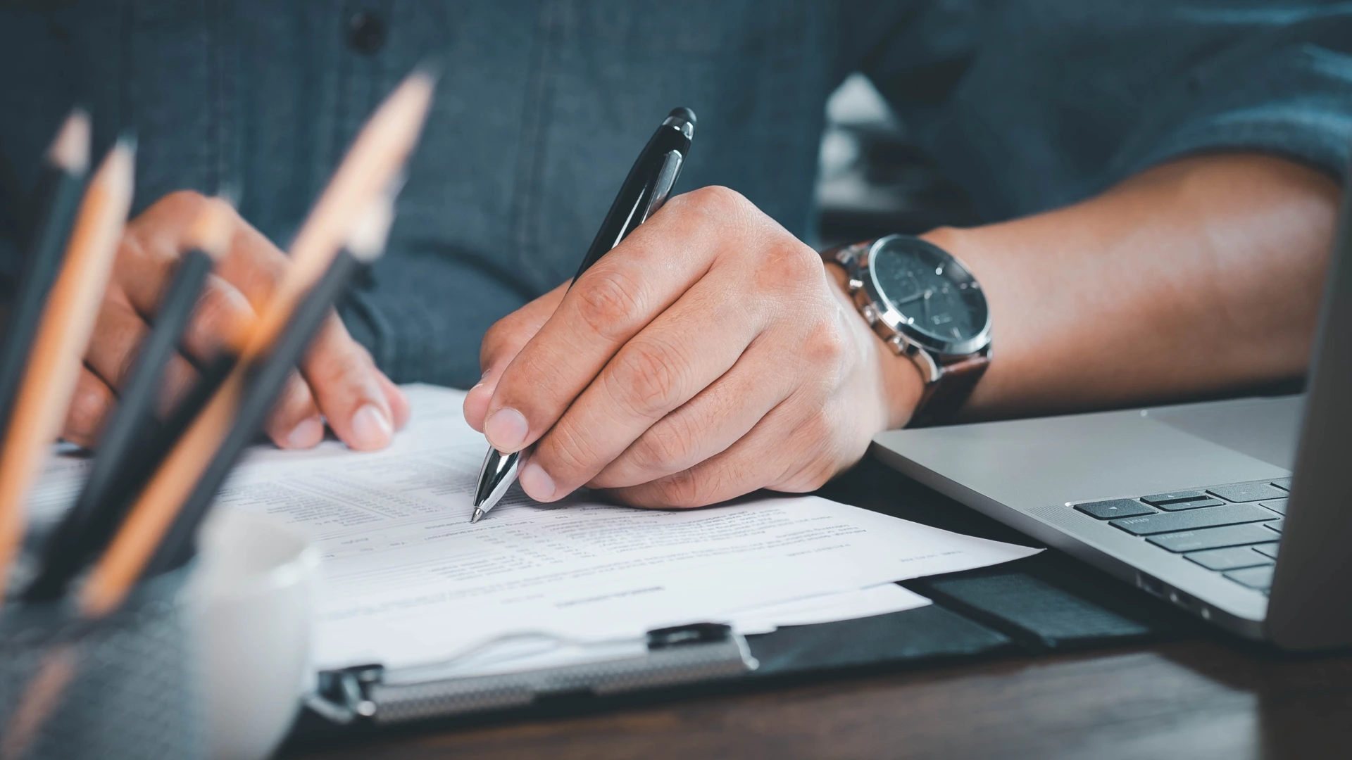 Close-up of Hand using writing pen with questionnaire or paperwork survey question