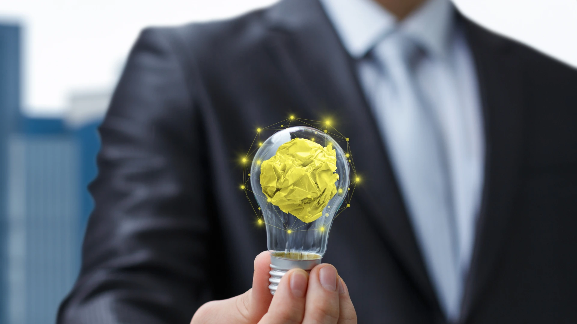 Concept of searching for new business ideas. A businessman says in his hands a light bulb with a crumpled piece of paper as a search for a solution and the emergence of an idea.