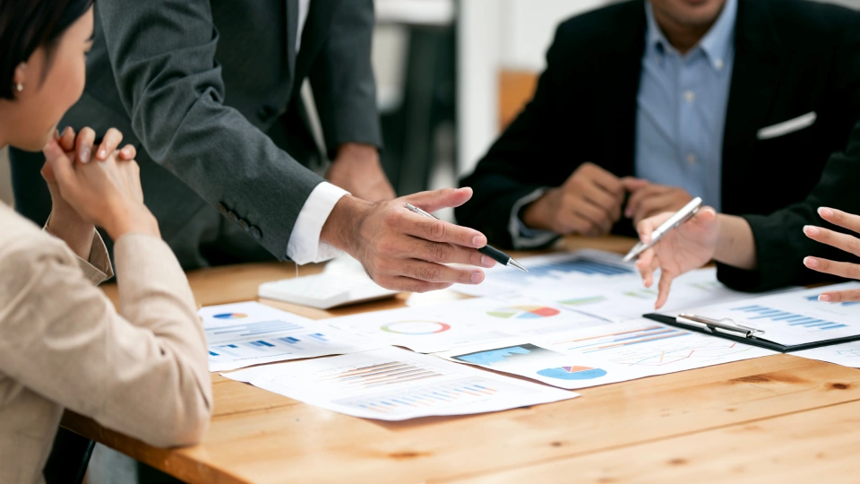 Diverse coworkers working together in boardroom, brainstorming, discussing and analyzing and planning business strategy