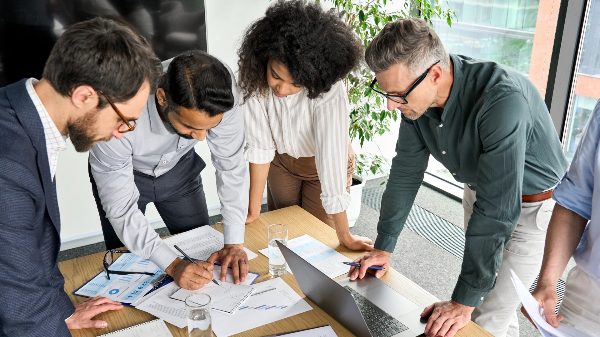 Diverse international executive business people group brainstorming at boardroom meeting table.