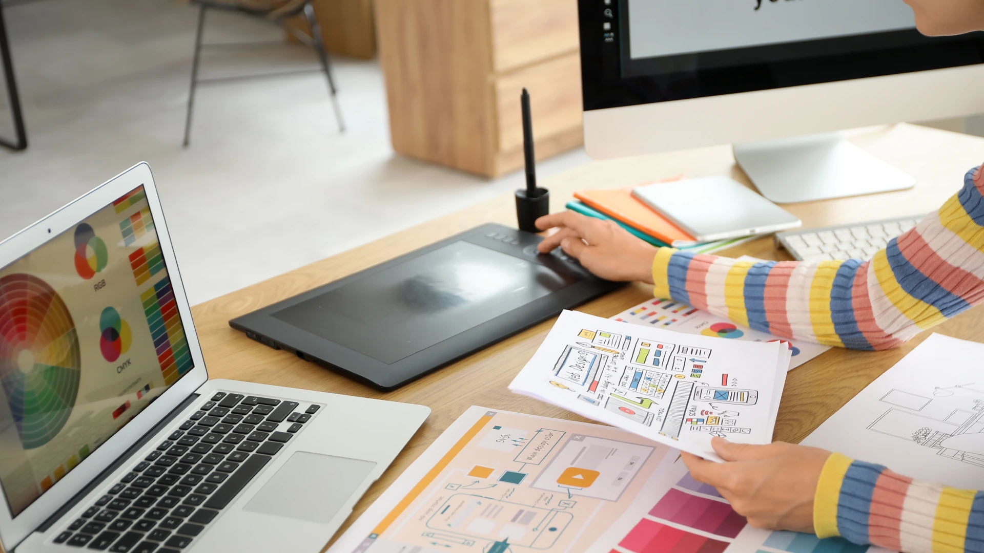 Female graphic designer with drawing working at table in office