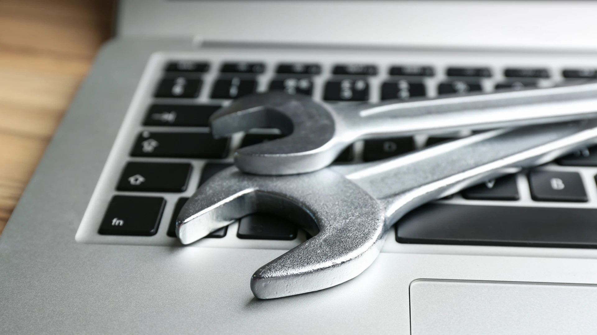 Laptop and spanners on table