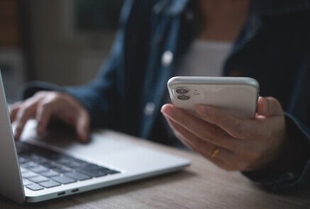 Person using laptop and phone