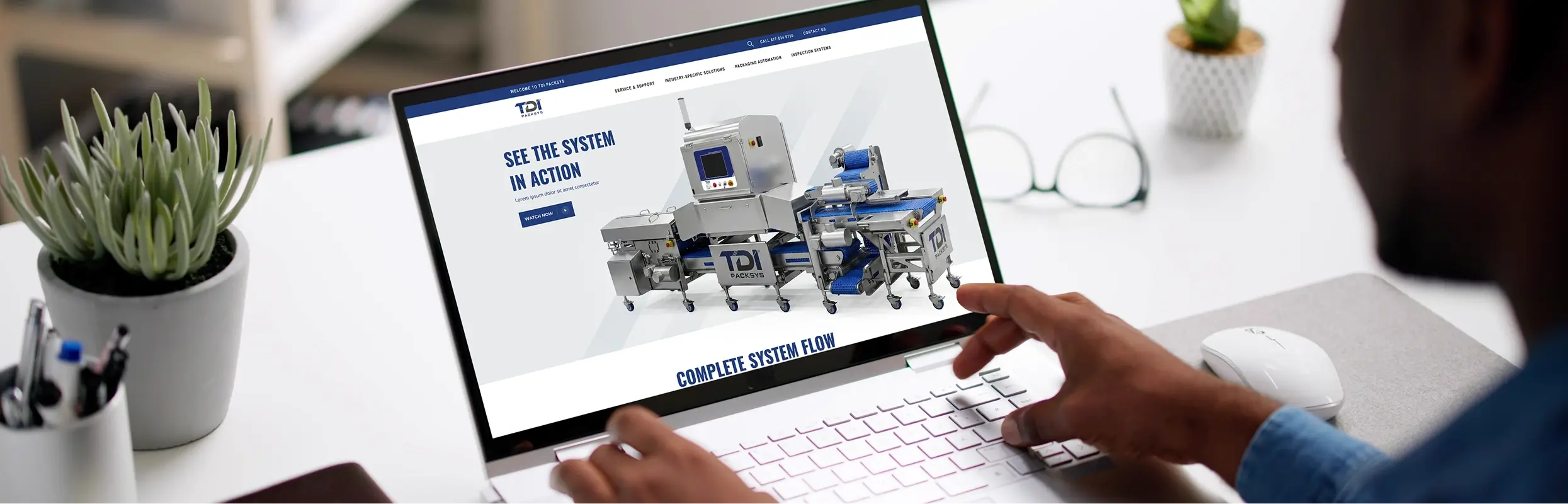Person viewing TDI Packsys website on a laptop