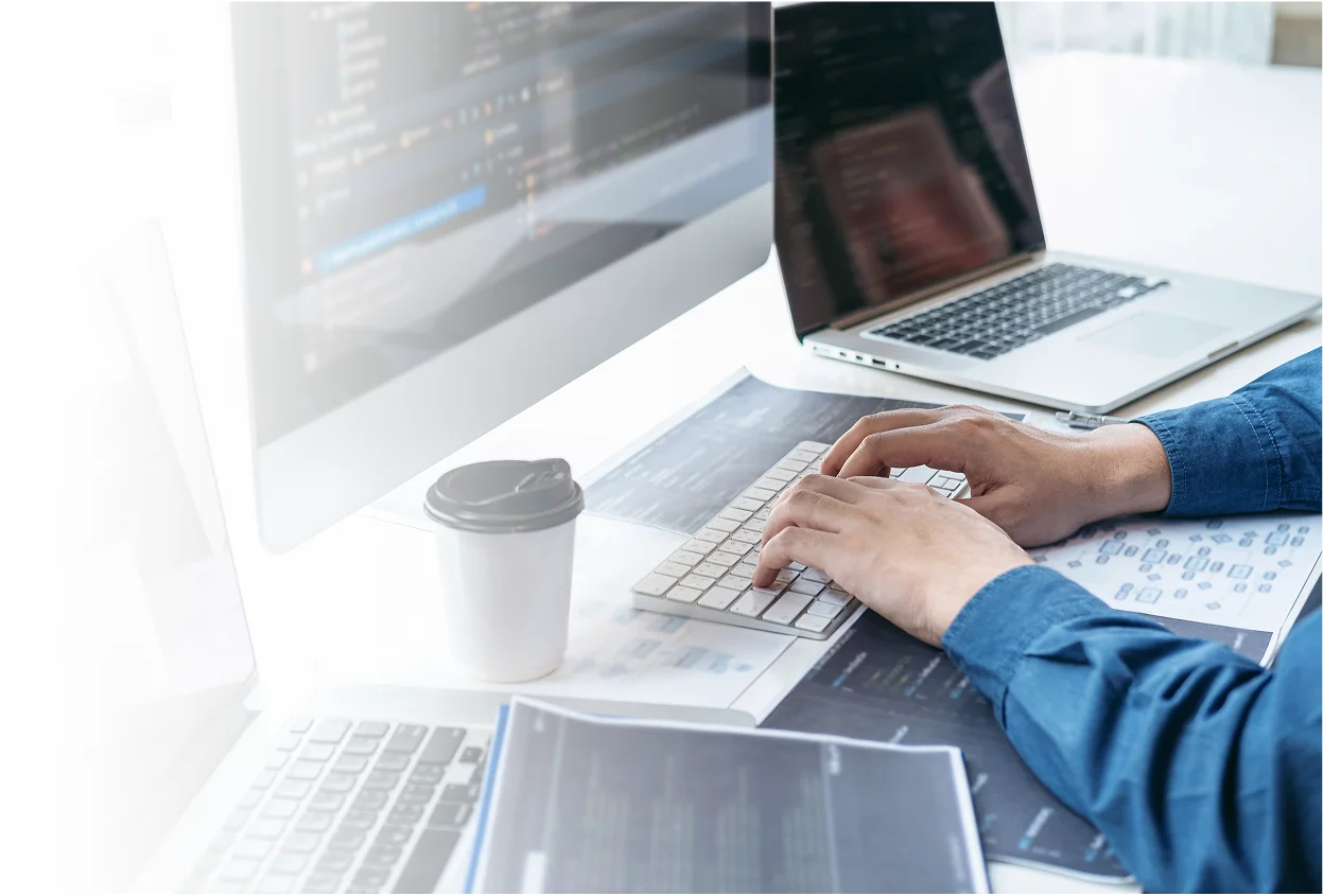 Person working on a laptop with multiple screens