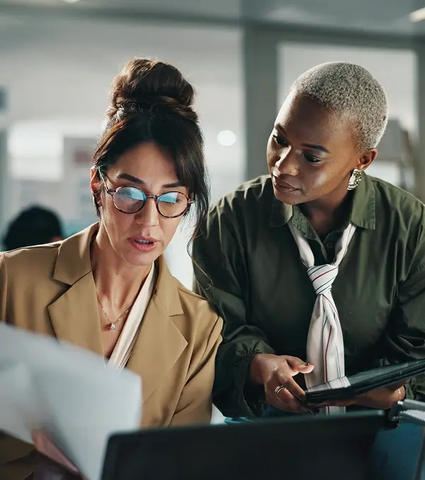 Professional colleagues reviewing documents together on a laptop in an office