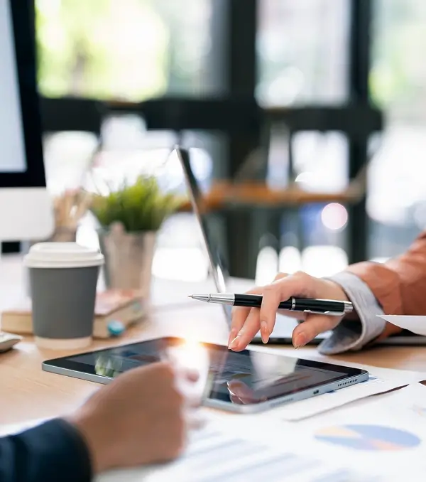 Professionals reviewing charts on a tablet during a meeting