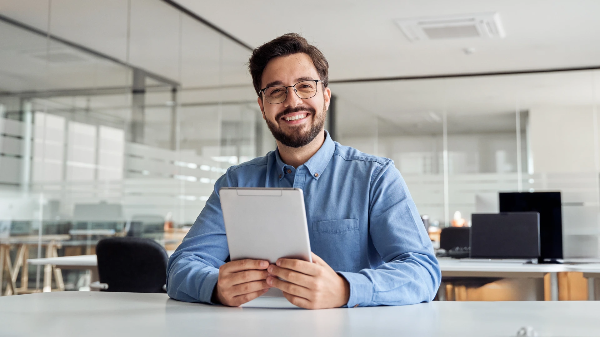 Smiling busy young business man manager using tablet