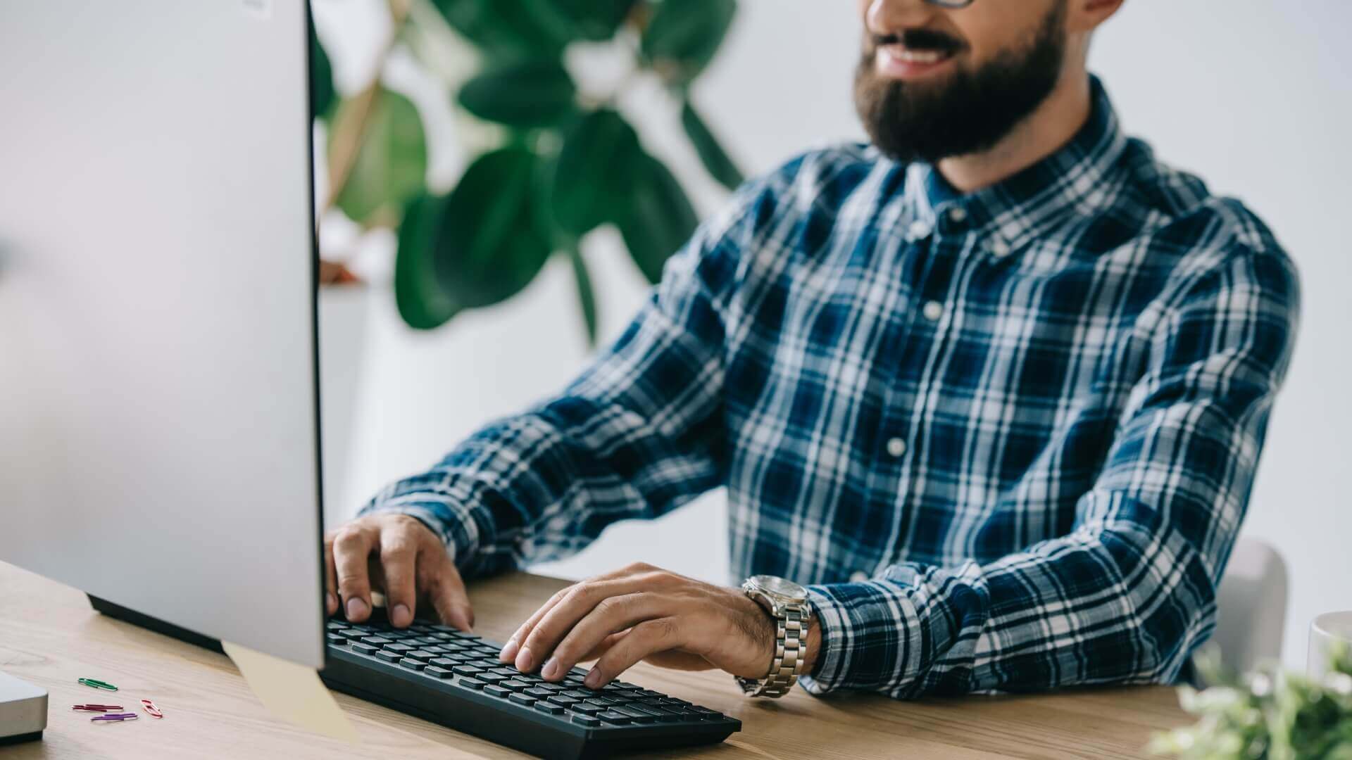 Smiling man while typing at keyboard