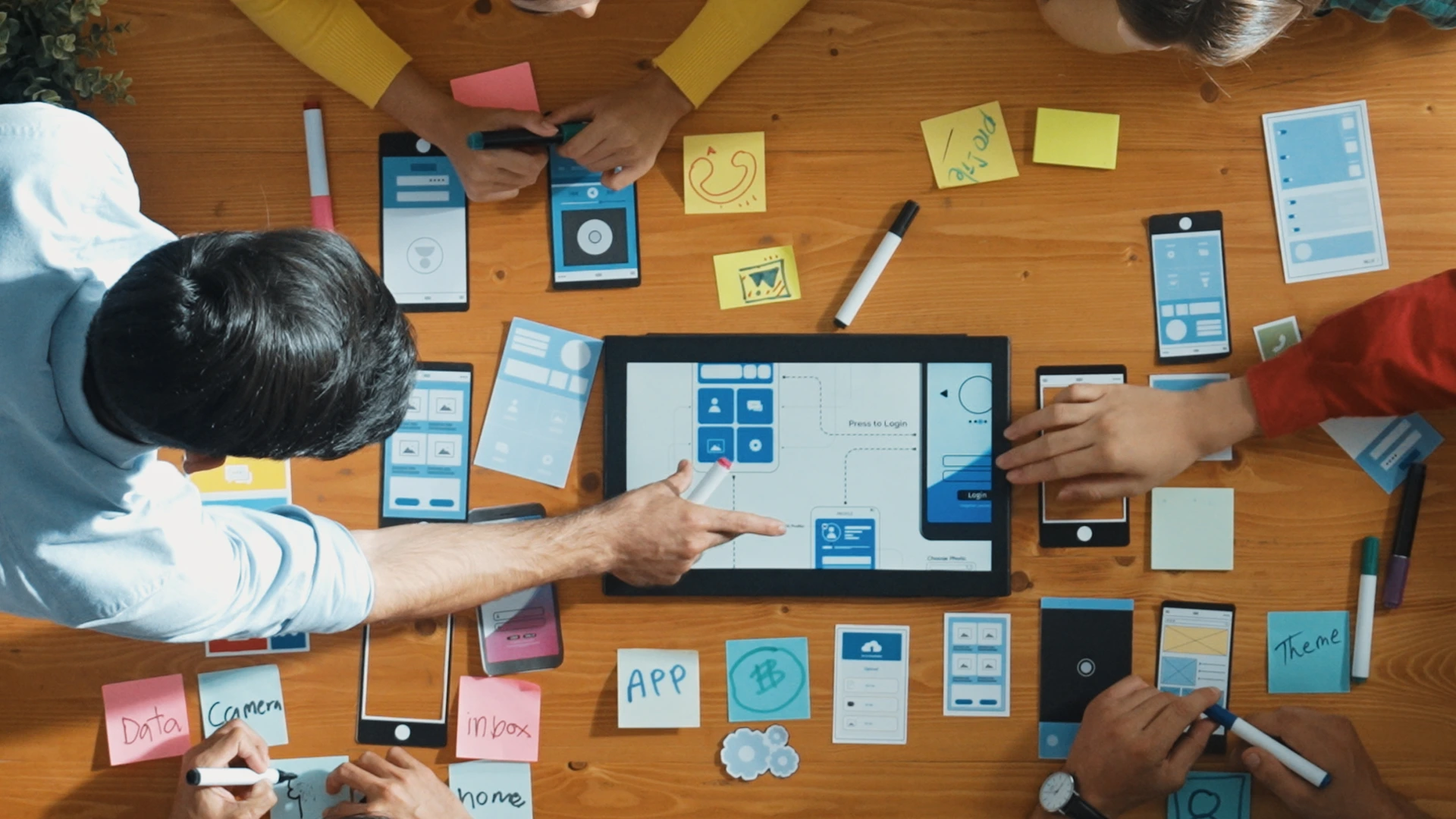 Top down view of business team writing idea on sticky note while planing for Ux Ui design for mobile phone interface