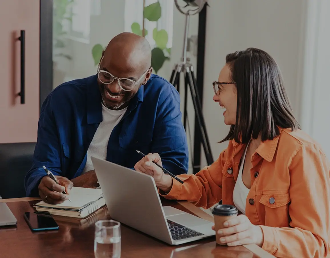 Two coworkers collaborating at a laptop