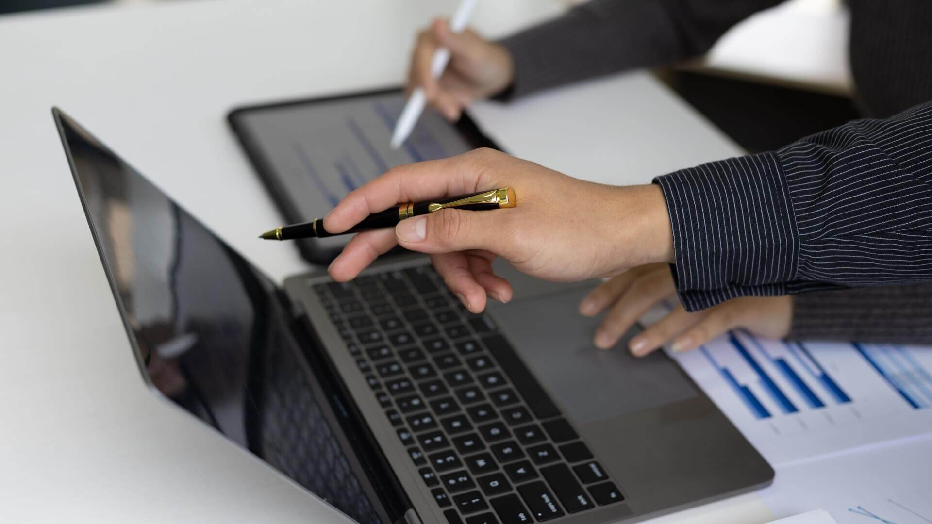 Two person pointing a something in laptop