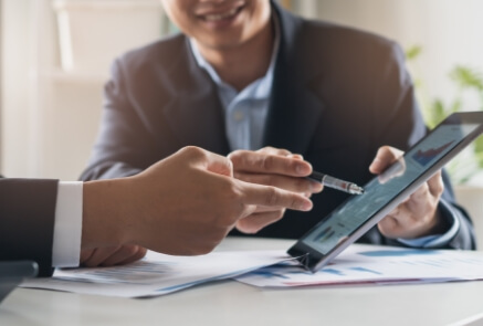 Two person pointing something in a tablet