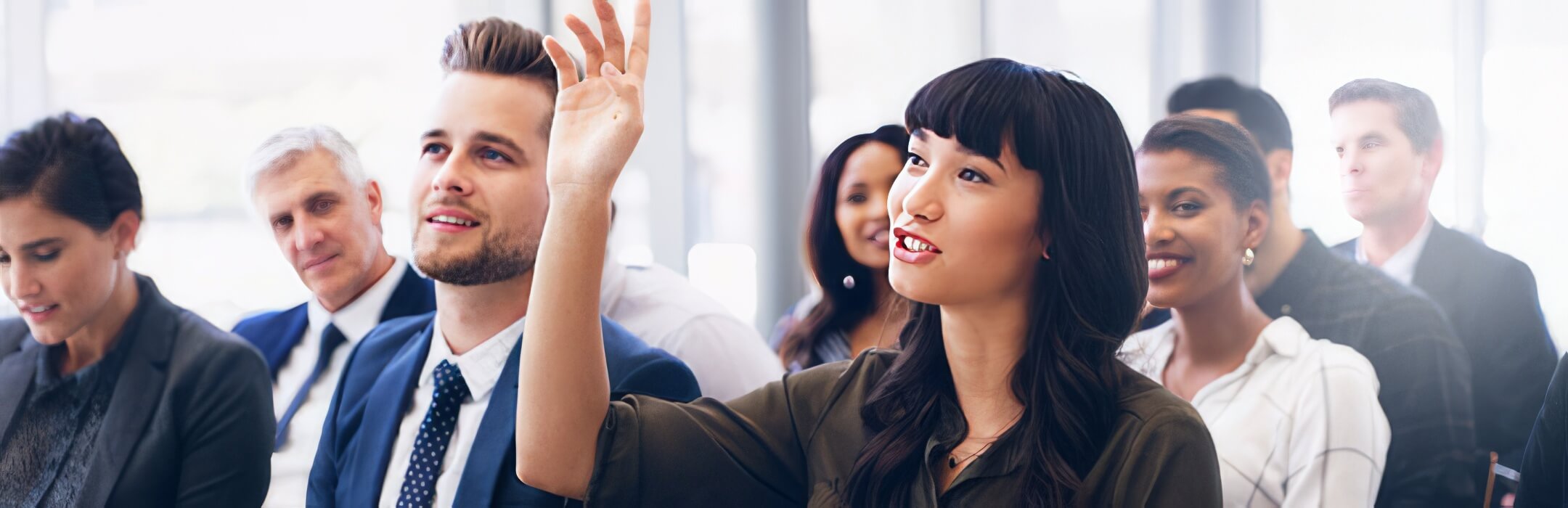 person raising their hand in a group of people