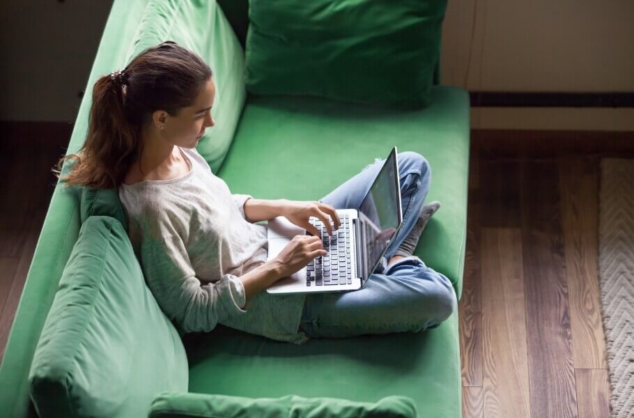 Woman at green sofa while working