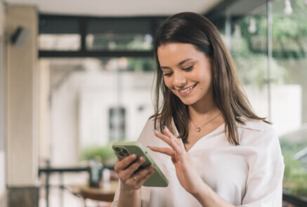 Women smiling while checking her phone