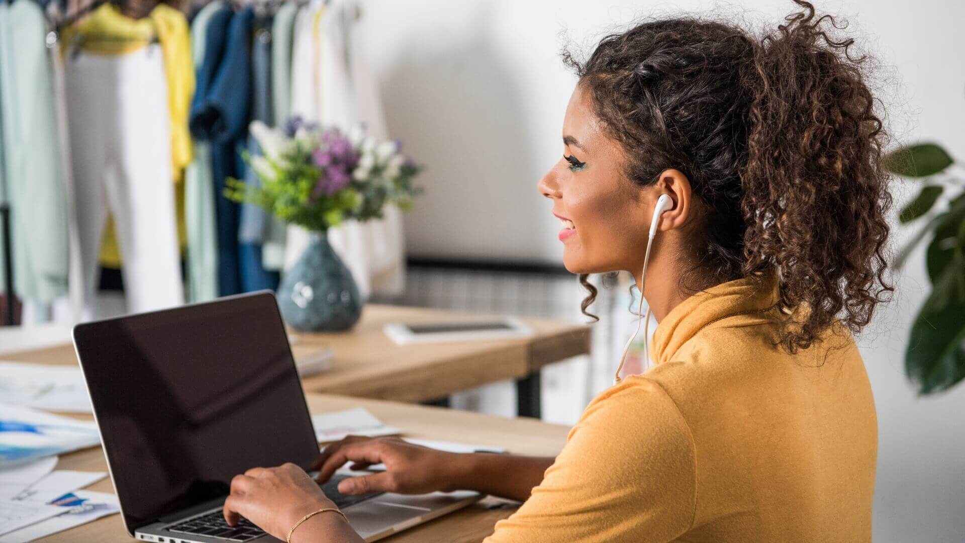 Women wearing yellow sleves using a laptop while listening Music