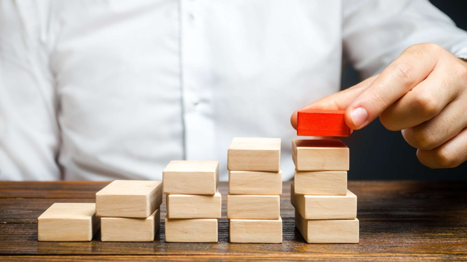 a man building ladder or growth chart from blocks