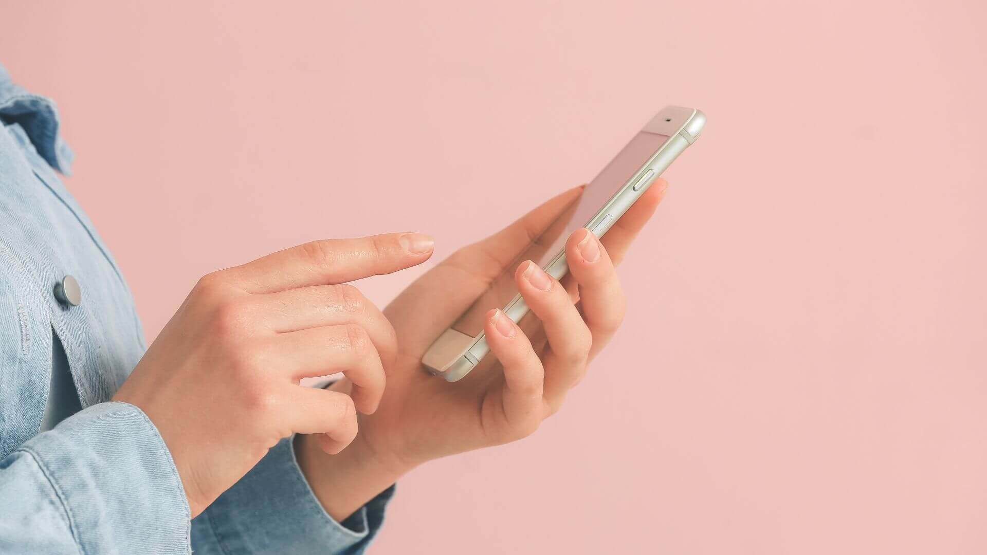 a person in the pink wall using a phone