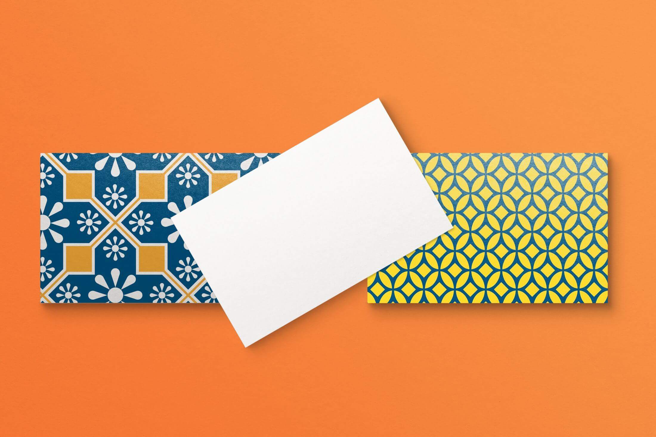 A mockup of an abstract, colorful business card design with geometric patterns, presented on an orange background for a visual impact.