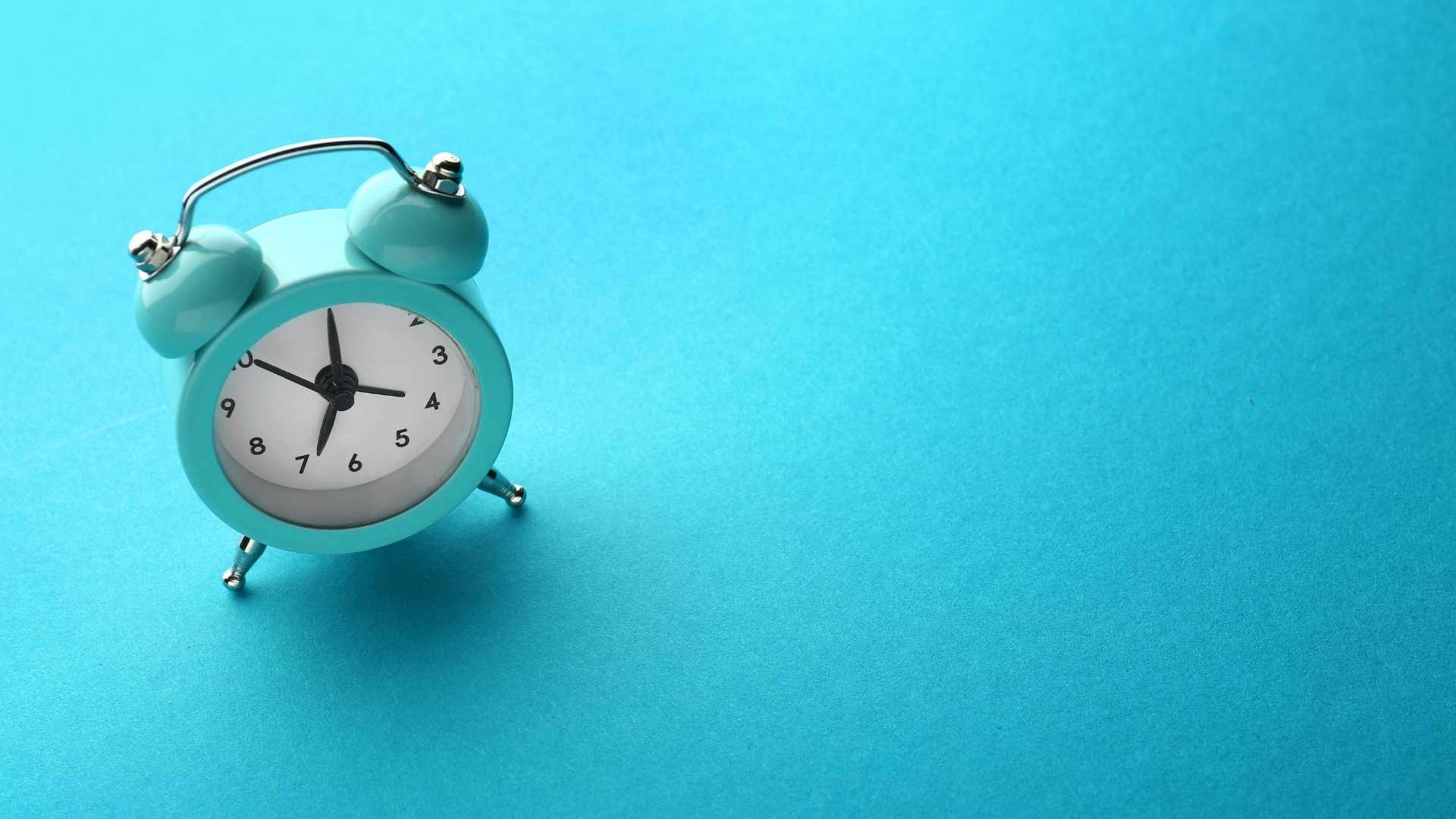 alarm clock on colored background