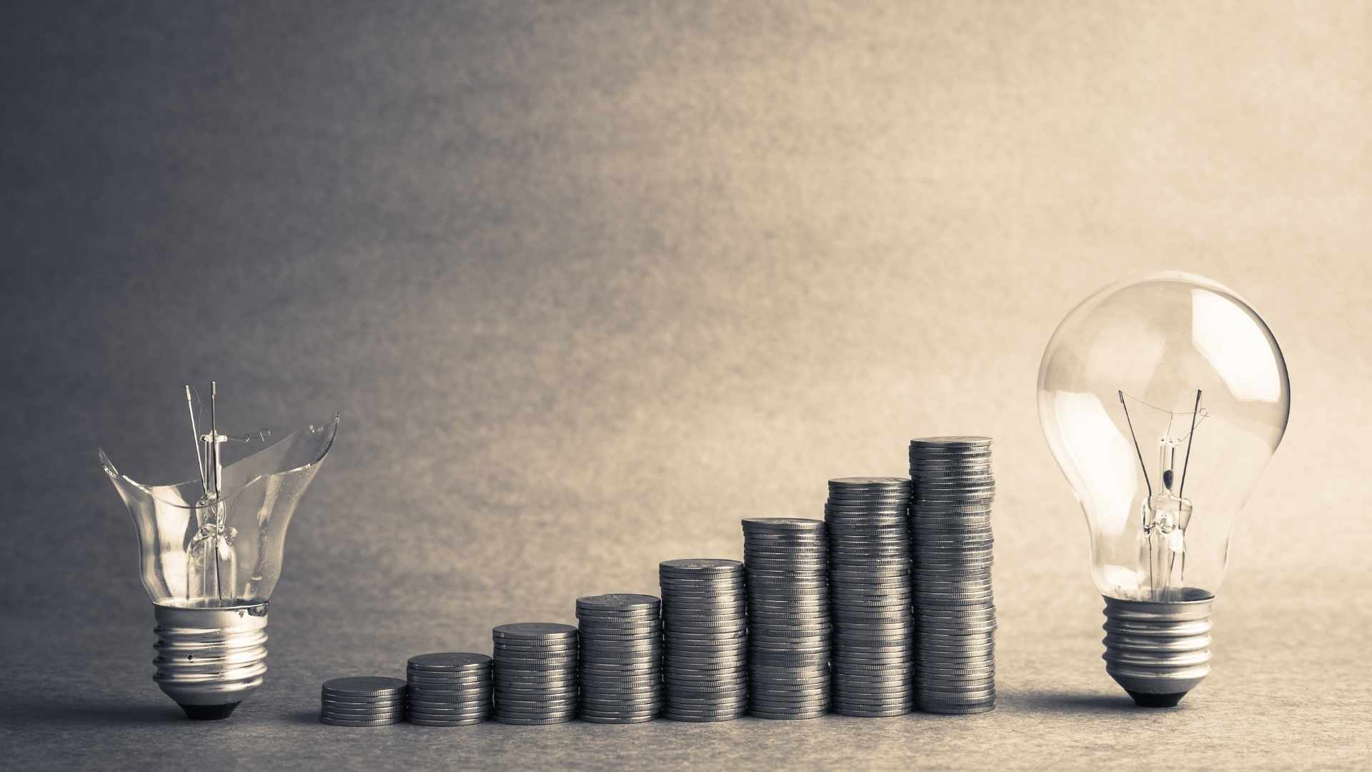 broken and fixed bulb with stacked coins in the middle