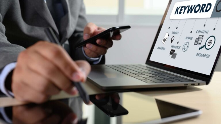 business man using his phone and laptop for SEO