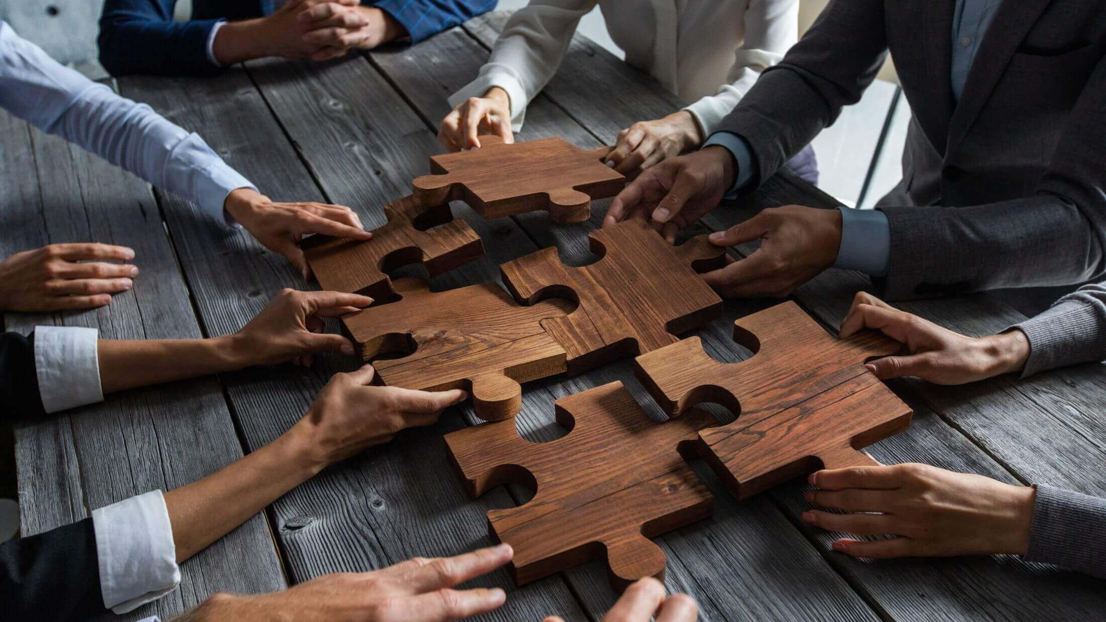business people holding wooden puzzle pieces as business data branch concept