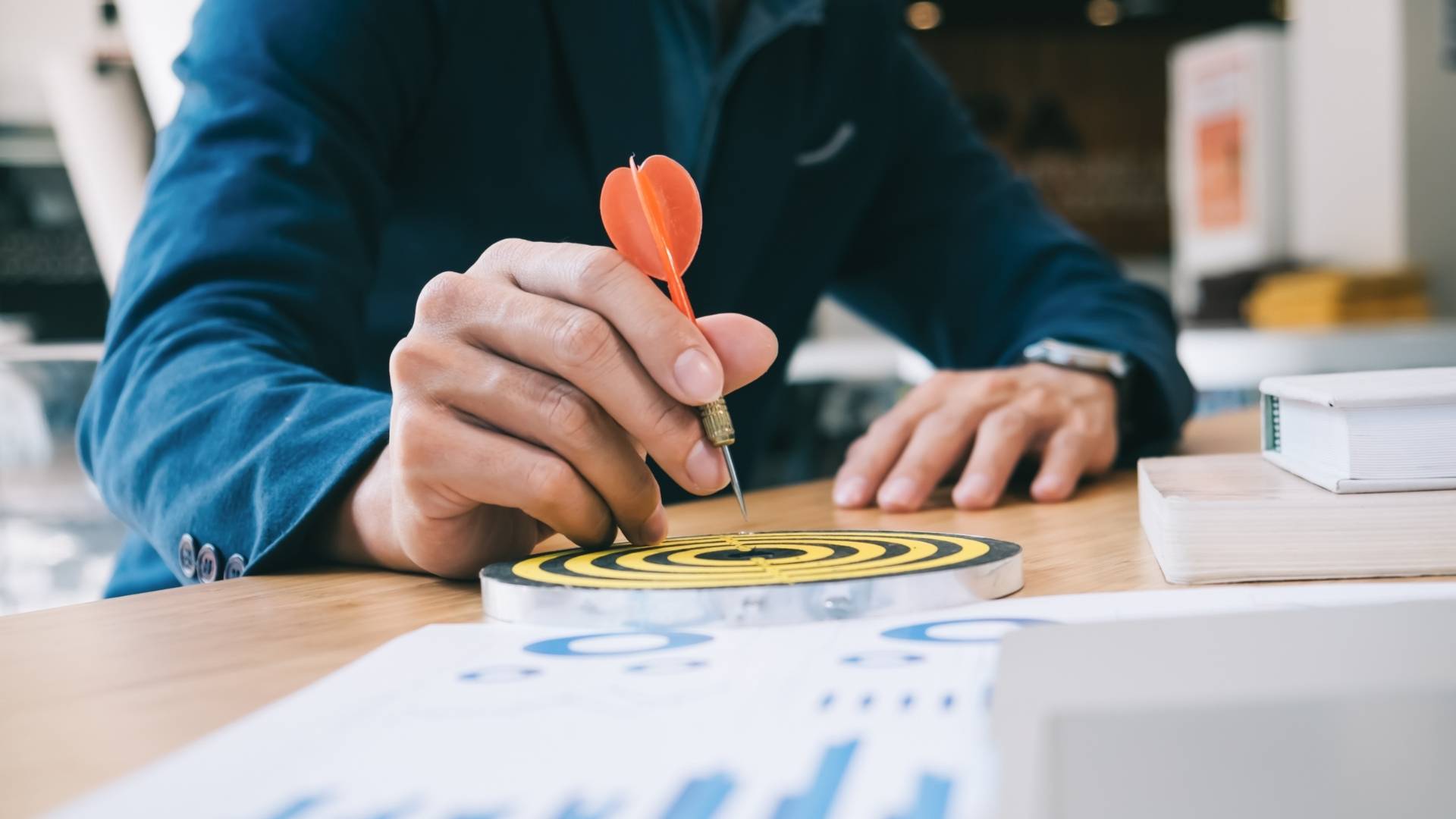 businessman holding a darts aiming at the target