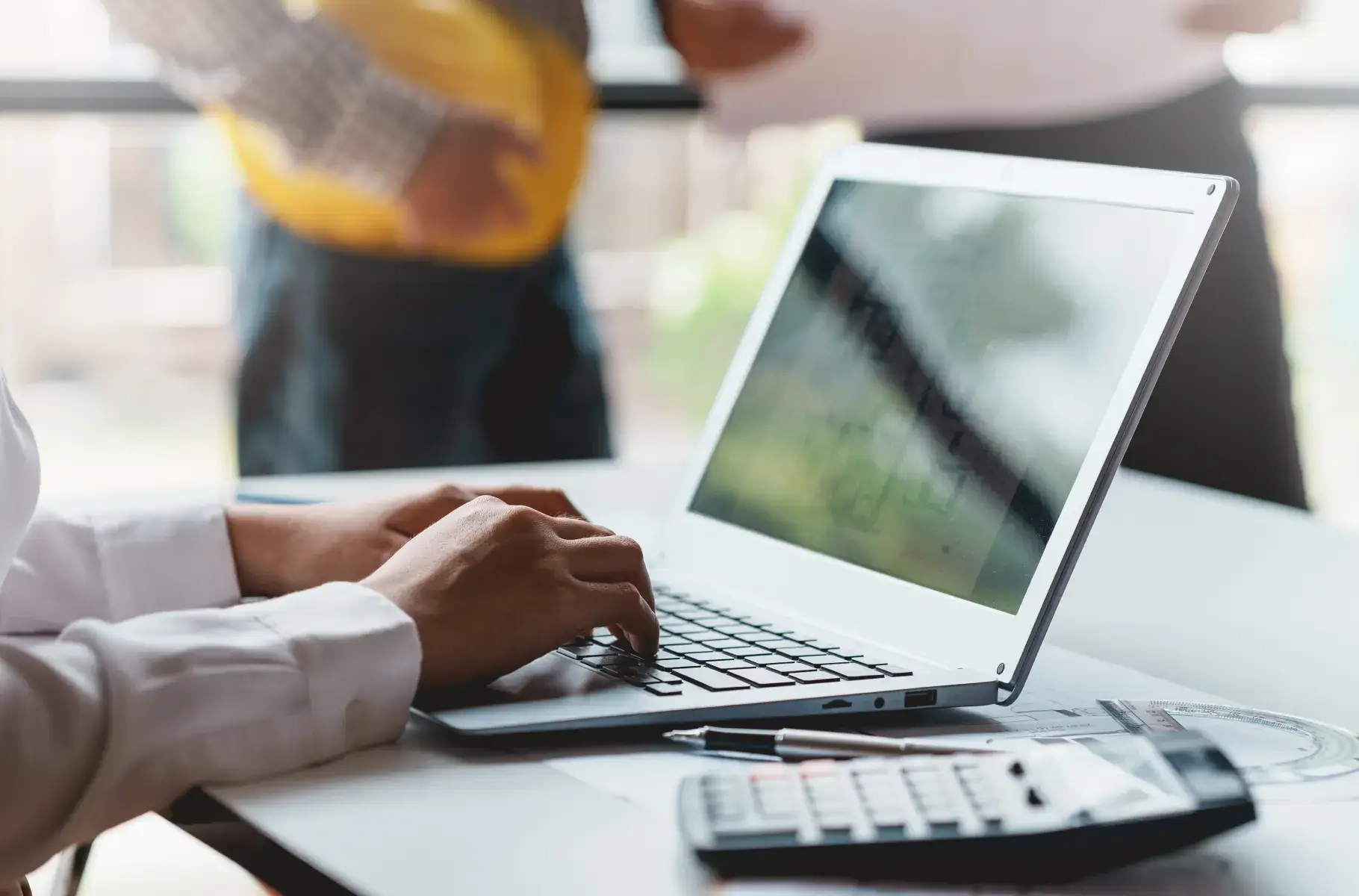 businessman using his laptop along side calculator