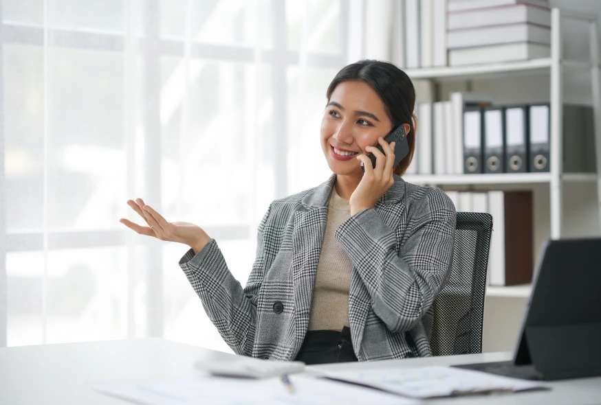 businesswoman in a grey blazer talking over the phone