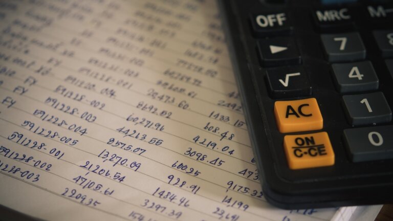 calculator on top of numbers in a notebook