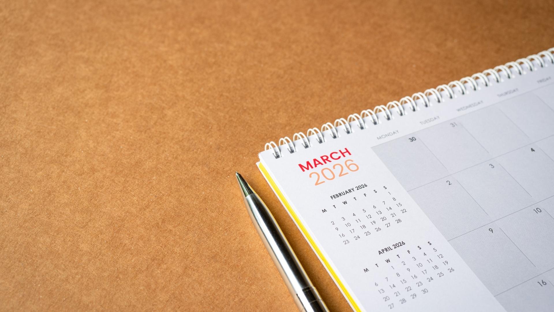 calendar with pen beside of it