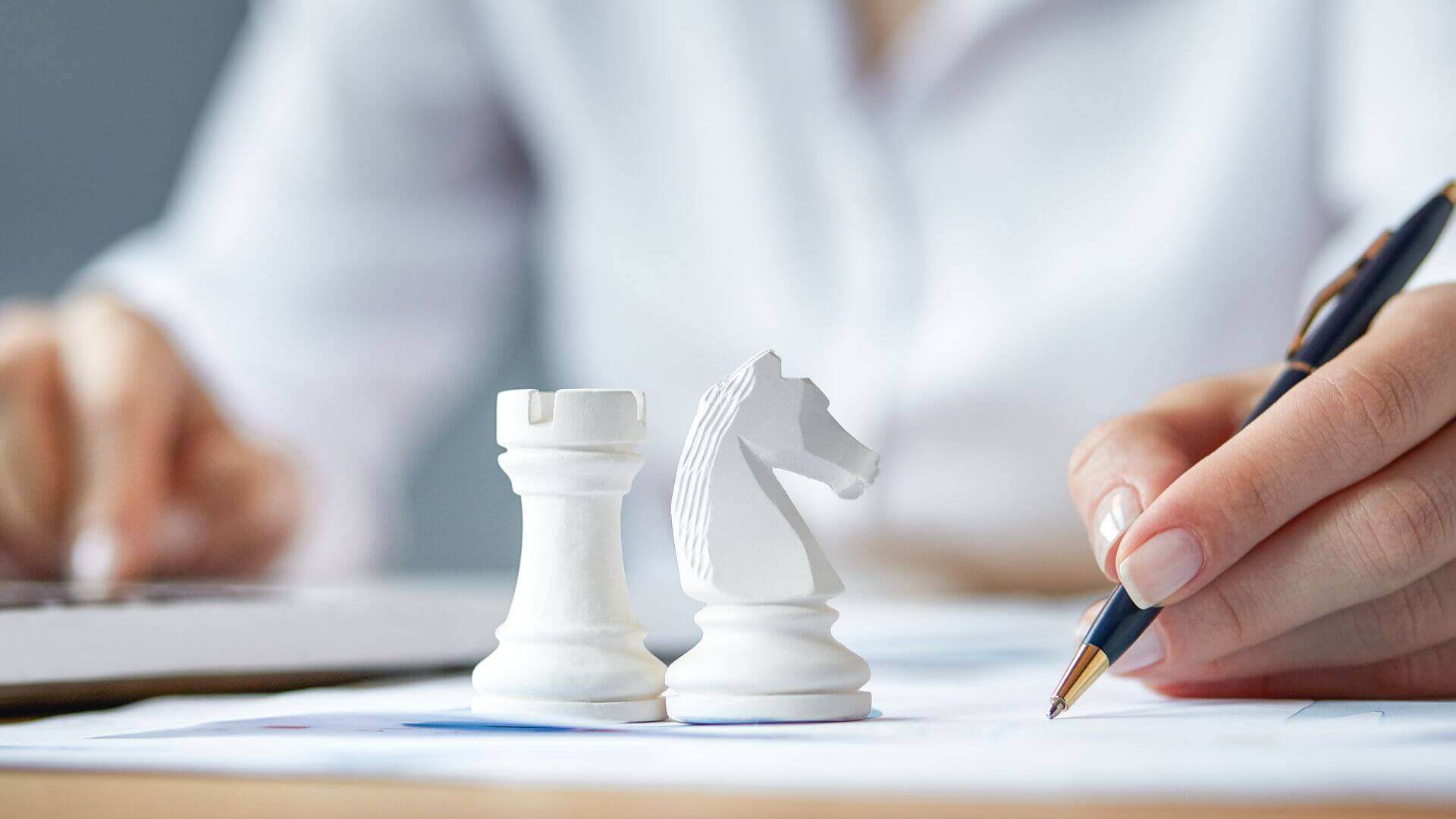 chess pieces and a man writing