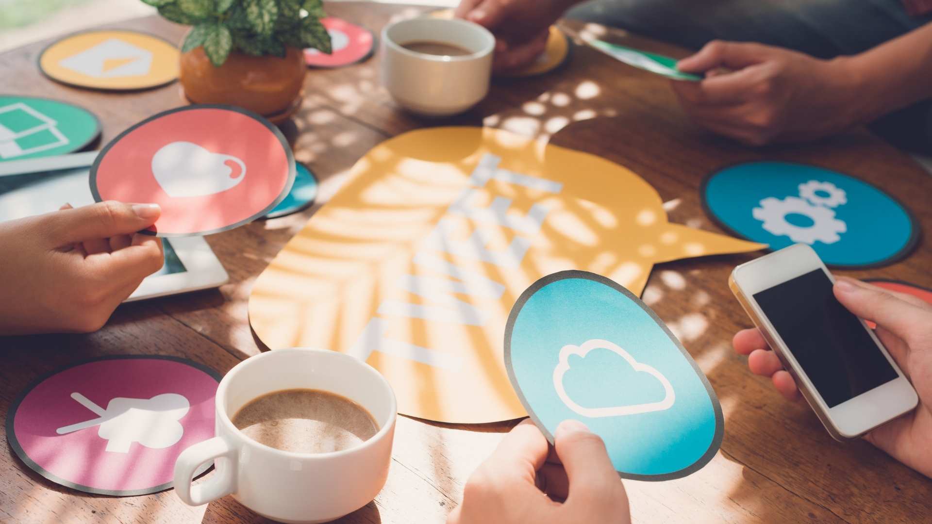 close-up of people holding paper social media icons