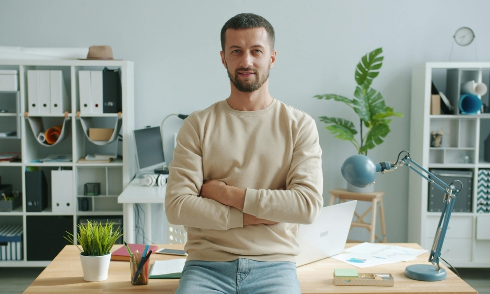 confident man standing behind his desk