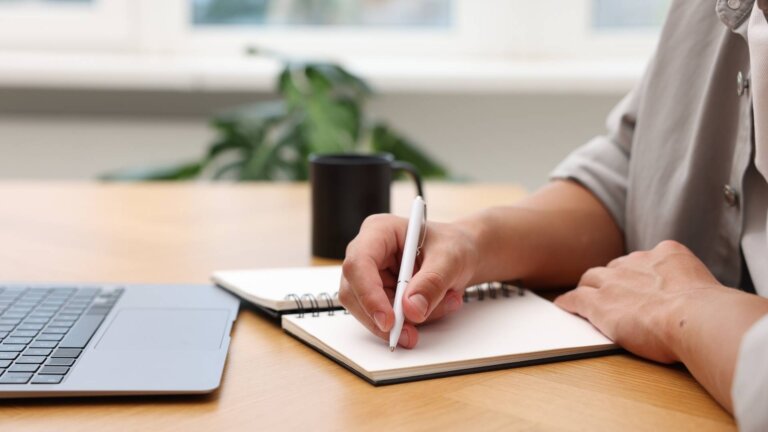 copywriter taking notes in front of the laptop