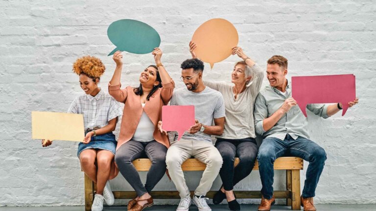 diverse group of people holding a speech bubble