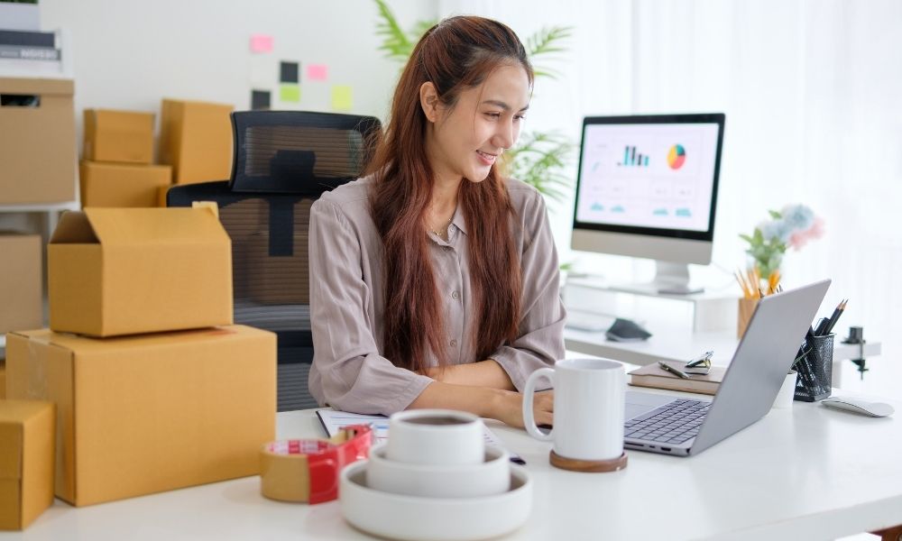 female online seller working on her lap to process e-commerce sale
