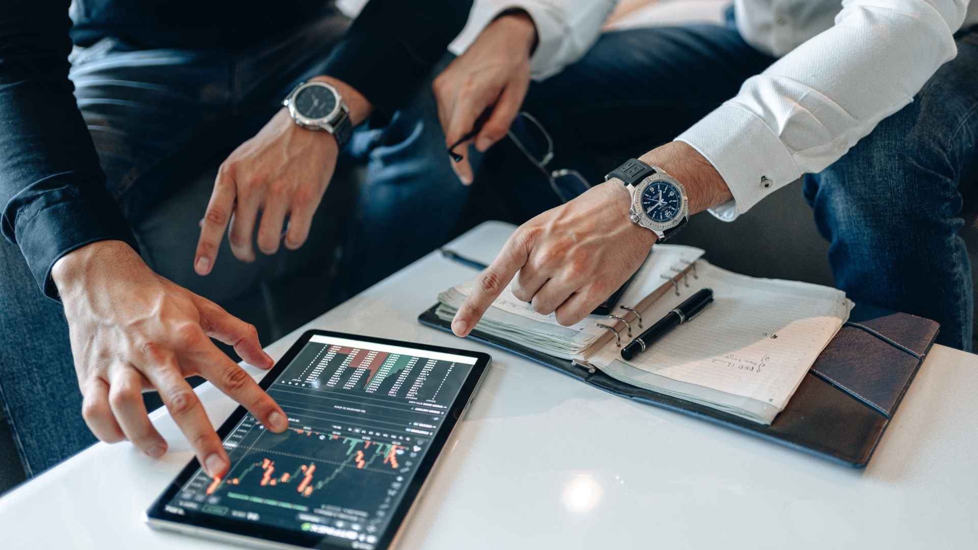 fingers on ipad with graph on screen