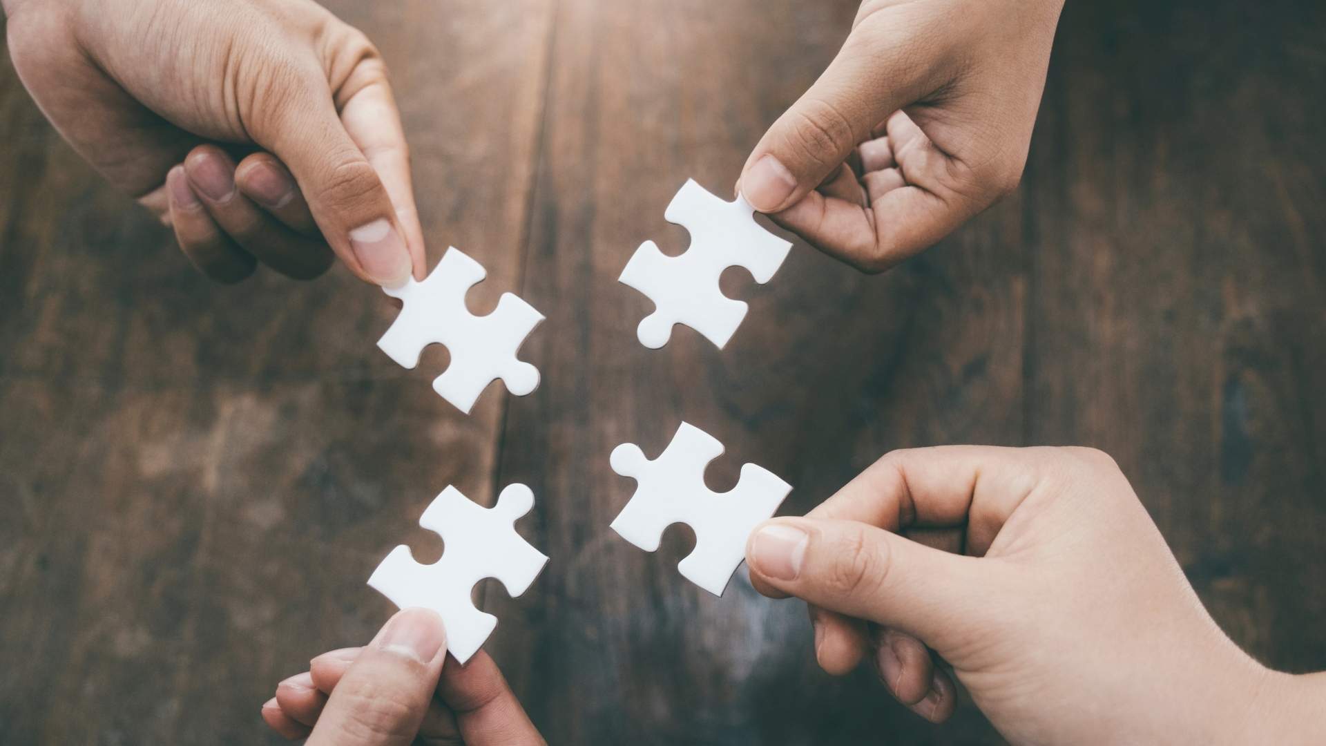 four people holding puzzle pieces