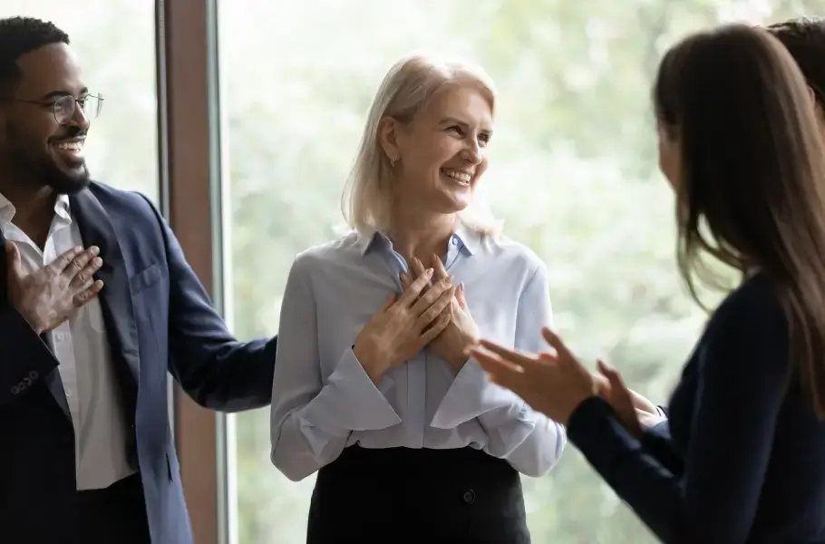 Group of people applauding a smiling woman